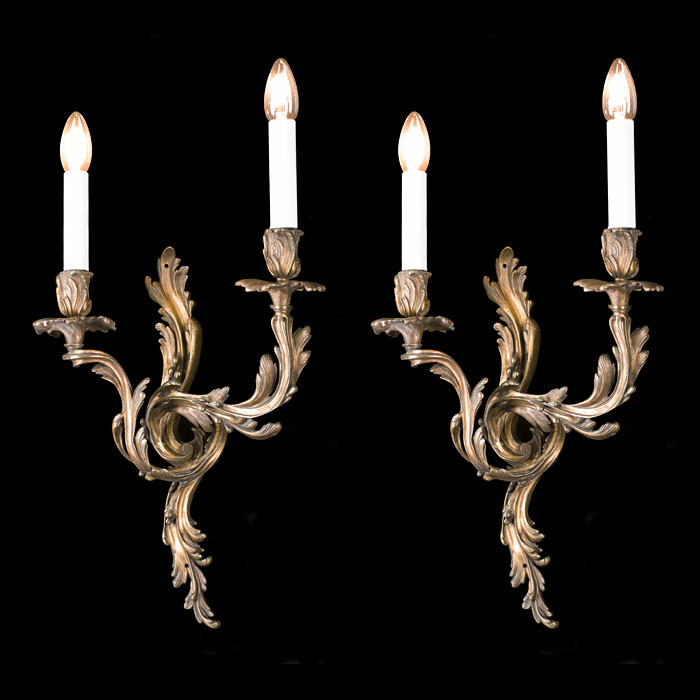 A Rococo style pair of brass wall lights